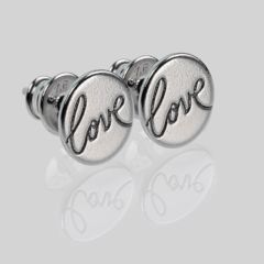 Makroaufnahme von schöne Ohrstecker aus Silber mit Gravur Love und Spiegelung