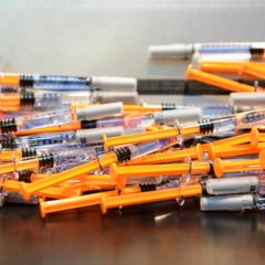 Eine Ansammlung an orangenen Spritzen mit Impfstoff oder anderen Medikamenten